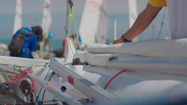 Sailors are preparing a small sailing boat