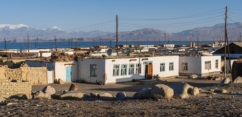 Landscape panoramic view of Karakul village after sunrise, with lake Karakul and snow-capped mountains in background, Murghab, Gorno-Badakhshan, Tajikistan Pamir