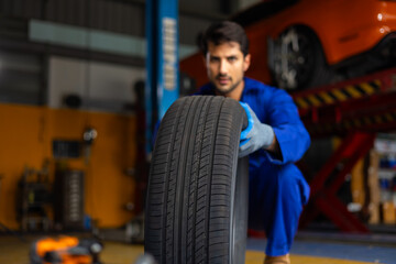 Close up tyre. Mechanic man holding tire. Car maintenance and auto service garage concept