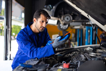 hispanic latin male mechanic repairs car in garage. Closeup hand. Auto car mechanic checking the oil level of the car engine. Car repair and maintenance