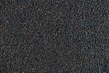 Black tea granulated texture. Indian black tea granules assam texture or background, close-up, high resolution.