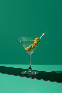 C&oacute;ctel de Martini seco con aceitunas sobre fondo verde