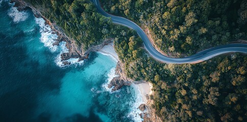 Aerial view of a winding road along a coastline with blue water.