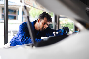mechanical man working  with tools and spanner. Hispanic latin male mechanic repairs car in garage....