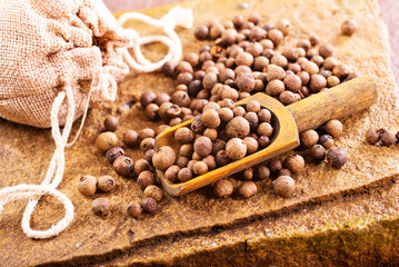 Pile of Black peppercorns seeds on stone board