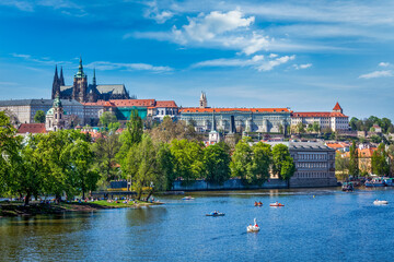 Panorama view of Vltava river and Gradchany (Prague Castle) and St. Vitus Cathedral and Charles bridge an people in paddle boats in the Prague, Czech Republic