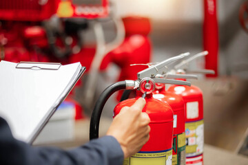 Naklejka premium Engineer are checking and inspection a fire extinguishers tank in the fire control room for safety training and fire prevention.