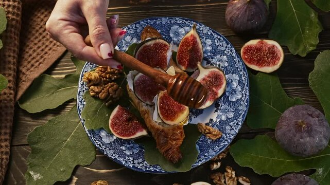 Sweet golden honey pouring on ripe figs slices, walnuts. Healthy breakfast, natural dessert, juicy organic fig, exotic vegetarian food background.