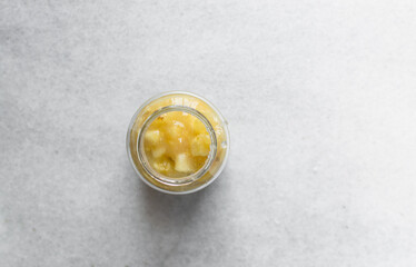 pineapple cheong in a glass jar on a white background, korean pineapple cheong in a transparent jar, pineapple in sugar syrup, process of making pineapple cheong