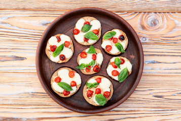 Italian mini pizza . Aubergine (eggplant ) with mozzarella cheese and basil . On rustic background