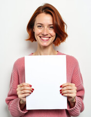 Naklejka premium A portrait of a woman with a cheerful expression, holding a blank white placard.
