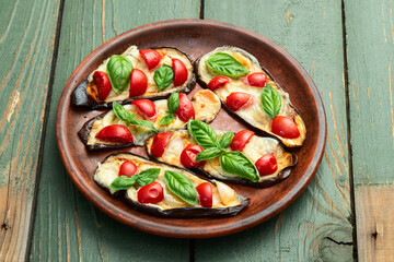 Italian mini pizza . Aubergine (eggplant ) with mozzarella cheese and basil . On rustic background