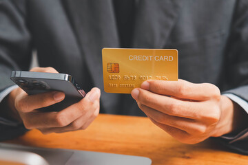 Close up Male hands holding credit card and smartphone, man paying online, credit card shopping, using banking service, entering information, shopping, ordering in internet store, doing secure payment