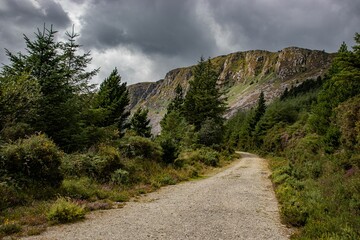 View of an empty road and the deserted mountain in a rugged landscape. Menacing clouds hang over...