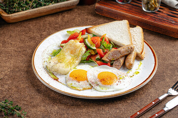 Portion of restaurant breakfast with fried eggs and sausages