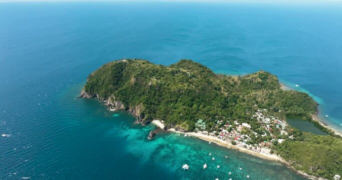 Aerial drone of volcanic island Apo in a marine reserve. Negros, Philippines. Popular dive site and snorkeling destination with tourists.