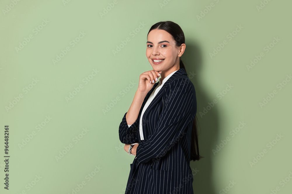 Wall mural Beautiful woman in black striped suit on green background