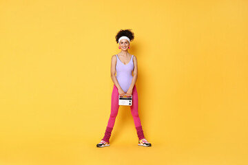 Aerobics. Woman with radio receiver on orange background