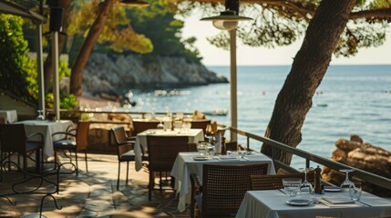 Obraz premium A peaceful seaside restaurant with elegantly set tables overlooking a picturesque ocean view, perfect for a serene dining experience.