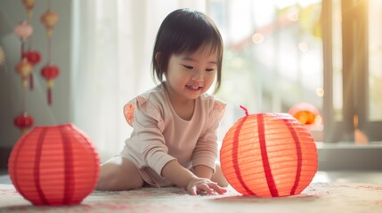 Fototapeta premium A little girl in a light-colored dress joyfully plays with illuminated red paper lanterns, celebrating in a warmly lit room filled with festive decor.