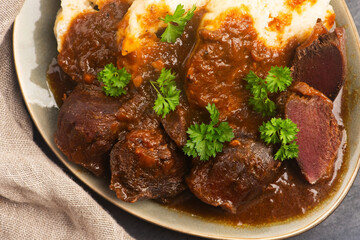 Stewed goose stomach.  Traditional Polish meat on a dark background.