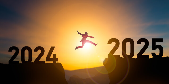 Happy new year 2025,Silhouette BusinessMan jumping from 2024 cliff to 2025 cliff on sky background.New Year's 2025,planning,challenge or career path,business strategy,opportunity and change concept