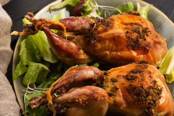 Baked tasty quails on ceramics plate with salad