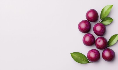 Fresh plums with green leaves on a white background. High-quality image perfect for fruit, food, and healthy eating concepts.