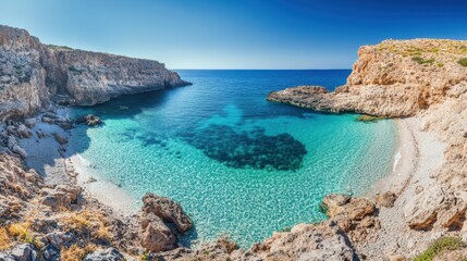 Serene Seaside Escape: Wide-Angle View of Remote Beach with Turquoise Waters, Rugged Cliffs, and Clear Blue Sky