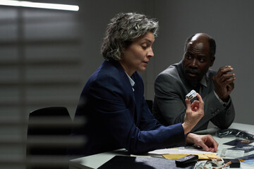 Two business professionals engaged in an intense discussion in a corporate setting. One person attentively listening while the other explaining a point, showcasing collaboration and strategy