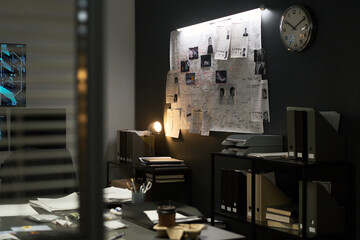 Modern office workspace featuring illuminated bulletin board filled with various documents and photos, indicating active brainstorming and project planning