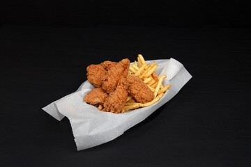 Cheeseburger with Fried Chicken Wings, French Fries, Onion Rings, and Dipping Sauces – Delicious Fast Food Platter on Black Background