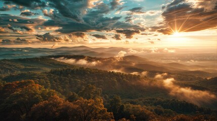 Dramatic sunset casting golden light over a misty mountain landscape, with layers of hills and clouds creating a stunning view..