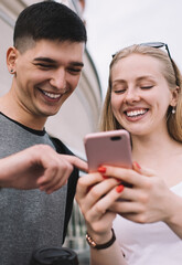 Gladden Caucasian hipster guys laughing while watching funny comedy movie trailer on online website for film critics connecting to 4g wireless for browsing internet, concept of positive friendship