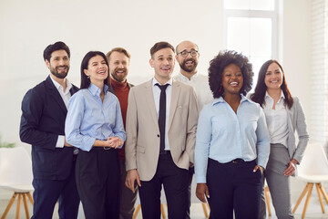 Business partners with happy and surprised facial expressions during an official meeting or event. Multiracial colleagues are watching something together and are happy about important news.