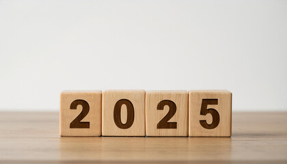 Wooden cubes with number 2025 on wooden table, white wall. New Year.