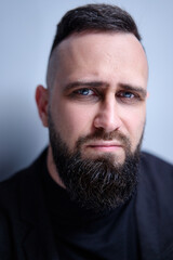 Studio portrait of young handsome man with beard.