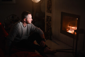 Man sitting at home by the fireplace