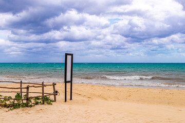 Green turquoise blank sign for labeling on beach nature Mexico.