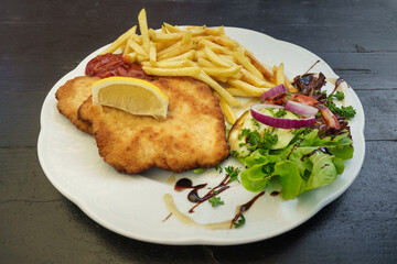 Schnitzel mit Pommes Frites, Ketchup und Salat als Beilage