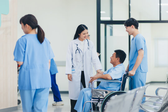 Happy asian woman doctor talking patient with wheelchair in hospital