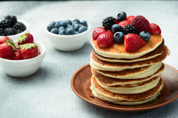 Stack of homemade american pancakes with berries . Top view