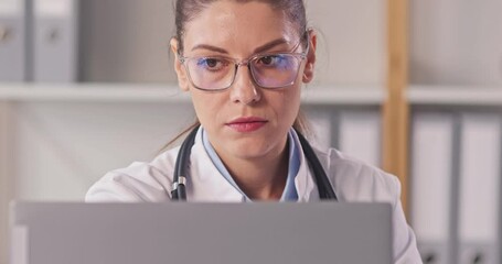 Friendly woman online doctor telehealth worker in glasses waves hello at office notebook PC, listens to patient, answers questions, gives medical advice, smiles and says goodbye at end of consultation