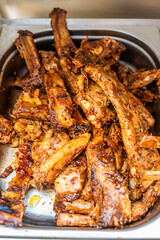 Juicy looking marinated grilled meat in stainless steel box