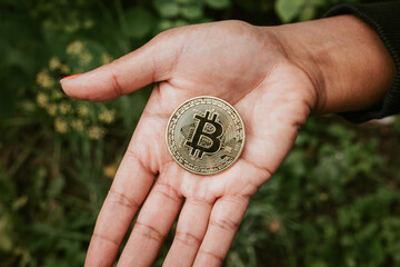Woman holding a Bitcoin in her hand. 
