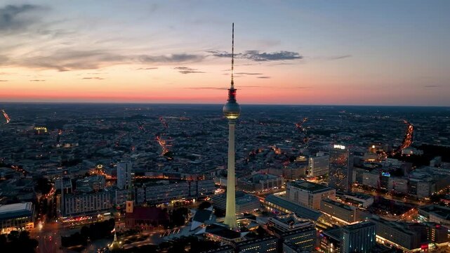 Aerial video shows a vibrant cityscape with a majestic tower famous places architectural landmarks TV Tower, Alexanderplatz at night. Berlin, Germany