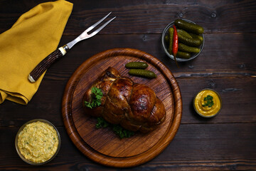 baked meat, cowboy butter, mustard and pickled cucumbers on a wooden table