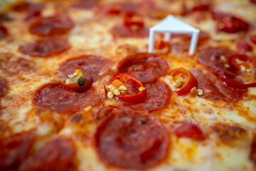 Close-up shot of a diavola pizza with a shallow depth of field. The pizza looks very tasty, featuring visible ham, chili peppers, and cheese.