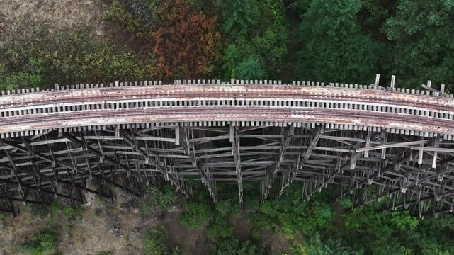 Curved wooden train trestle in a forested