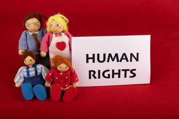 Wooden Dolls and Human Rights Message on Red Backdrop